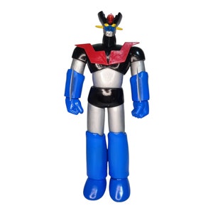 Pode incluir: Um brinquedo de robô prateado e preto com pernas e braços azuis. O robô tem uma peça de peito vermelha e preta e uma cabeça amarela e azul.