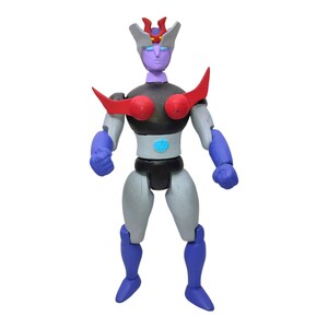 Puede incluir: Una figura de acción azul, roja y negra con una cara morada y una gema azul en el pecho. La figura tiene un cuerpo esculpido y articulado.