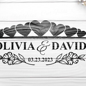 May include: Black and white wedding sign with a row of hearts and the names Olivia & David and the date 03.23.2023.