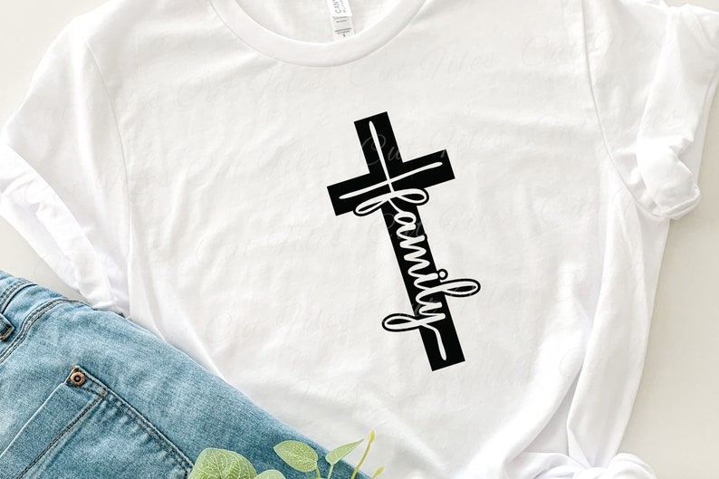 Puede incluir: Camiseta blanca con una cruz negra y la palabra "family" escrita verticalmente en la cruz.