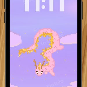 Op de afbeelding: Een smartphone toont een gepixeld roze en gouden wezen op een lavendelkleurige achtergrond. De tijd 11:11 wordt in het wit weergegeven. De tekst "Studio te Lintelo" is ook aanwezig.
