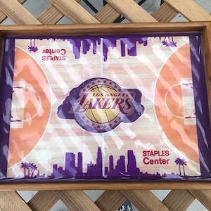 May include: A wooden serving tray with a purple and orange basketball court design. The tray features the Los Angeles Lakers logo and the text "STAPLES Center".