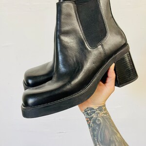 May include: Black leather ankle boots with a chunky heel and a square toe.