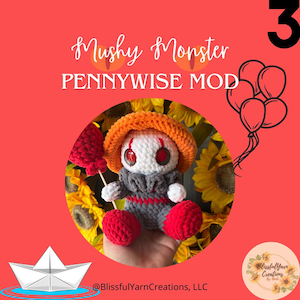 May include: A crocheted Pennywise the Dancing Clown plush toy holding a red balloon. The toy is wearing a white and gray outfit with a red and orange hat. The toy is sitting on a hand with sunflowers in the background. The text "Mushy Monster PENNYWISE MOD" is above the toy. The text "@BlissfulYarnCreations, LLC" is below the toy.