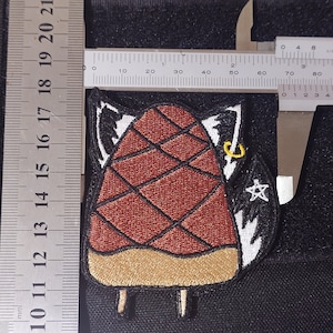 May include: A brown and white embroidered patch of a popsicle with a star and a horseshoe. The popsicle is about 6 cm tall.