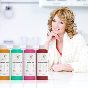 Może przedstawiać: Cztery butelki produkt&oacute;w do kąpieli i ciała z etykietami z napisem "Jersey Botanical" i r&oacute;żnymi zapachami: Pumpkin Spice, Mint Choco Chip, Bubble Gum i Strawberry Bubble. Butelki są ustawione na białej powierzchni.