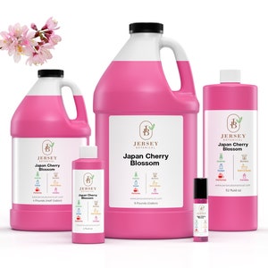 May include: Four bottles of Japan Cherry Blossom scented oil in various sizes. The bottles are pink and have a white label with the Jersey Botanical logo and product name. The smallest bottle is a 3.2 fluid ounce roll-on bottle. The other bottles are 16 fluid ounces, 32 fluid ounces, and 64 fluid ounces.