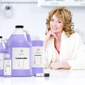 Op de afbeelding: Vier flessen lavendelolie in verschillende maten, van Jersey Botanicals. De flessen zijn paars en hebben een wit etiket met het bedrijfslogo en de woorden "Lavendel" en "Essenti&euml;le olie".