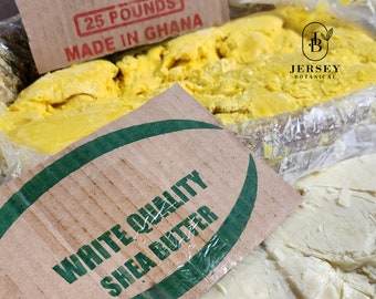 Puede incluir: Primer plano de una caja de cartón con una etiqueta que dice "25 POUNDS MADE IN GHANA". La caja está llena de manteca de karité amarilla. Una caja de cartón más pequeña con una etiqueta verde que dice "WHITE QUALITY SHEA BUTTER" cubre parcialmente la caja más grande. La caja más pequeña también está llena de manteca de karité, pero esta manteca de karité es blanca.