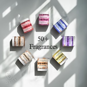 May include: An overhead shot of several jars of whipped body butter, each with a different fragrance label. The jars are arranged in a circle around the text "50+ Fragrances". The labels include "Pink Sugar", "Wet Watermelon", and "Oatmeal Milk".