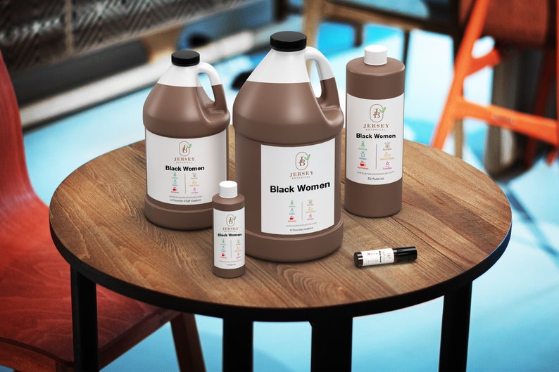 May include: Four brown bottles of essential oil on a wooden table. The bottles are labeled "Jersey Botanicals Black Women" and contain 1 oz, 4 oz, 12 oz, and 1/2 oz of oil.