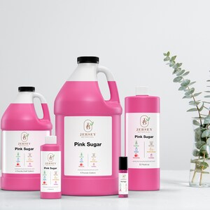 May include: Four bottles of pink sugar fragrance oil in different sizes. The bottles are labeled "Jersey Botanical" and "Pink Sugar". The smallest bottle is a roll-on and the largest bottle is a gallon.