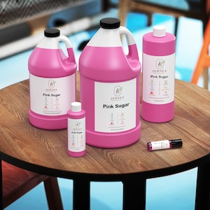 May include: Four bottles of pink sugar-scented liquid in various sizes, from a small 1 oz bottle to a large 1 gallon jug, all with the same label featuring the text "Jersey Aromatics" and "Pink Sugar". The bottles are on a wooden table.