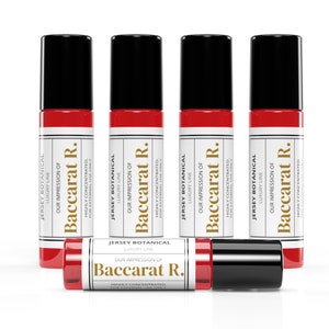 May include: A collection of five red and black roll-on perfume bottles. The bottles have a white label with the text "Jersey Botanical Luxury Line Our Impression of Baccarat R." The bottles are highly concentrated and for external use only.