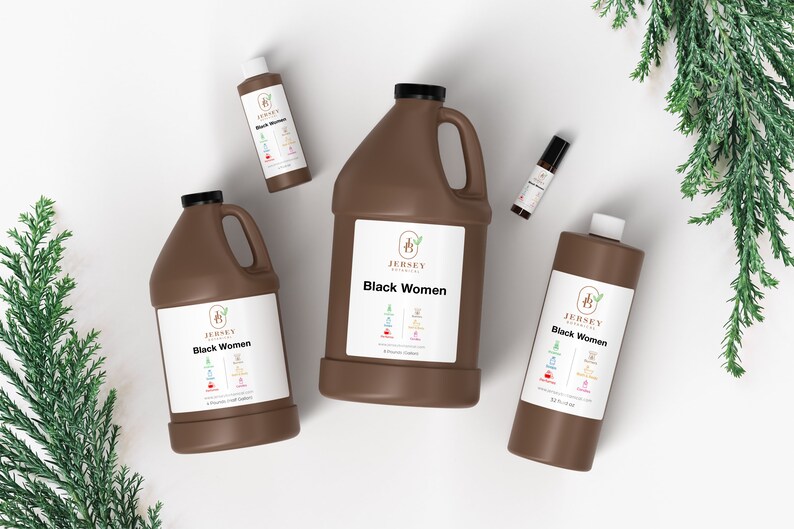 May include: Four brown bottles of "Black Women" essential oil blend by Jersey Botanicals. The bottles are in different sizes, including a small roll-on bottle, a small bottle, a medium bottle, and a large bottle. The bottles are on a white surface with green foliage in the background.