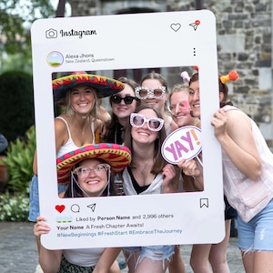 Puede incluir: Un grupo de personas sonrientes posan detrás de un marco blanco estilo Instagram. El marco incluye el logo de Instagram, un corazón y un icono de comentario. El texto en el marco dice "Alexa Jhons, New Zealand, Queenstown", "YAY!" y "Your Name A Fresh Chapter Awaits!"