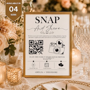 Könnte beinhalten: Ein goldgerahmtes Hochzeitsschild mit weißem Hintergrund und schwarzem Text, der SNAP And Share lautet. Es enthält einen QR-Code, ein Kamerasymbol mit einer Herz-Sprechblase sowie Anweisungen zum Scannen, Hinzufügen und Teilen von Fotos.