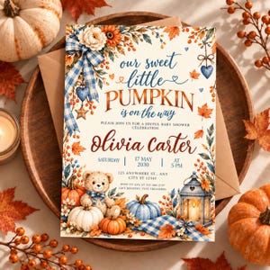 Puede incluir: Una tarjeta de invitación para baby shower con ilustraciones en acuarela de calabazas, un osito de peluche con un lazo de cuadros azules, una linterna y hojas de otoño. El texto dice: our sweet little PUMPKIN is on the way, Olivia carter, 17 MAY 2030.