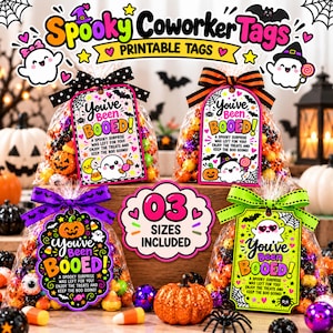 May include: Four clear plastic bags filled with colorful Halloween candies, each featuring a decorative paper tag with the text You've Been BOOED! and cartoon ghost illustrations. The tags are tied with patterned ribbons in black, orange, purple, and green.