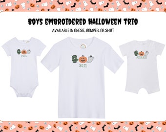 May include: White onesie, t-shirt, and romper featuring embroidered Halloween designs. The designs include a mummy, pumpkin, and ghost. Text on the garments reads "POUL", "SAM", and "JONATHAN". The text "BOYS EMBROIDERED HALLOWEEN TRIO" is also visible.