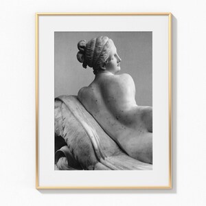 Puede incluir: Fotograf&iacute;a en blanco y negro de una escultura de m&aacute;rmol de una mujer reclinada. La escultura es de estilo cl&aacute;sico y la mujer est&aacute; representada de espaldas al espectador.