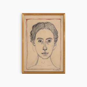 May include: A black and white pencil drawing of a person's face. The drawing is framed in a gold frame and is on a beige background.