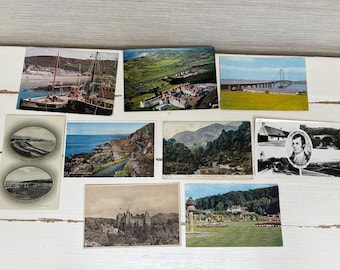 May include: A collection of vintage postcards featuring scenic views. The postcards depict landscapes, bridges, boats, and buildings. The color palette includes blues, greens, and browns, with some black and white images.