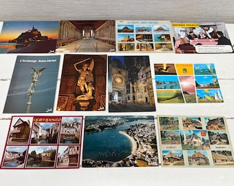 May include: A collection of vintage postcards featuring various French landmarks and scenes. The postcards showcase architectural structures, coastal views, and historical sites, with vibrant colors and detailed imagery.