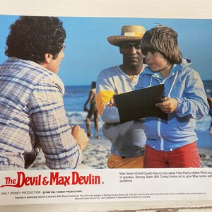 Peut inclure: Une affiche de film pour le film "The Devil & Max Devlin" mettant en scène trois acteurs. Les acteurs sont debout sur une plage avec un ciel bleu et l'océan en arrière-plan. Le texte sur l'affiche indique "The Devil & Max Devlin" et "A Walt Disney Production".