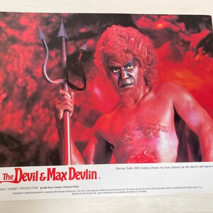 Puede incluir: Un póster de película para la película "The Devil & Max Devlin" con Bill Cosby como un diablo de piel roja sosteniendo un tridente. El texto en el póster dice "Barney Satin (Bill Cosby) muestra sus verdaderos colores como el brazo derecho del diablo."
