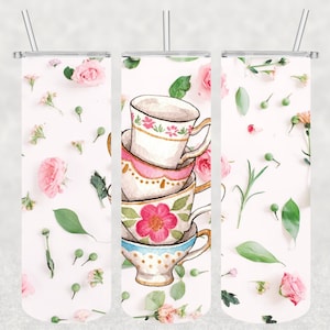 May include: A set of three 20 oz. stainless steel tumblers with a floral pattern and a stack of teacups. The tumblers are white with a pink, green, and white floral pattern. The teacups are white with pink, blue, and gold accents.