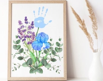 May include: A framed print of a watercolor painting featuring a blue iris, lavender flowers, and eucalyptus leaves. A blue handprint is visible in the upper left corner of the print.
