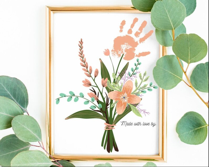 Puede incluir: Una impresi&oacute;n enmarcada con una huella de mano en el centro de un ramo de flores rosas y verdes. El texto "Made with love by" est&aacute; en la parte inferior de la impresi&oacute;n.