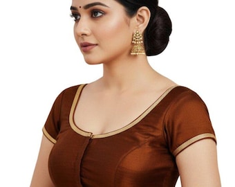 May include: A brown blouse with short sleeves and a scoop neckline, trimmed with gold-colored piping. The blouse has a button-up front and is made of a smooth, possibly satin-like fabric. The text "@priyankasboutiqu" is visible at the bottom.