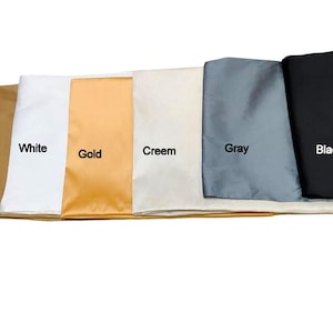 May include: A selection of fabric swatches in various colors, including dark gold, white, gold, cream, gray, and black. Each swatch is labeled with its respective color name in white text.