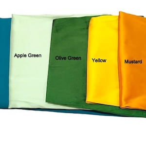 May include: A collection of folded fabric samples in various colors, including Teal Green, Apple Green, Olive Green, Yellow, and Mustard. Each sample is labeled with its respective color name in a clean, sans-serif font.