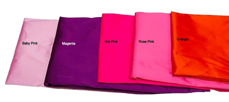 May include: Five folded fabric swatches in shades of pink and orange. The colors are labeled: Baby Pink, Magenta, Hot Pink, Rose Pink, and Orange. The fabric appears to be a smooth, possibly satin, material.