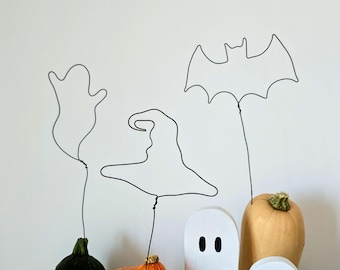 A Set of Three Wire Halloween Pumpkin Toppers as a Minimalist and Spooky Decor Accent