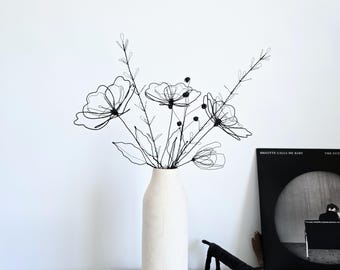 Het wilde weideboeket met drie wilde bloemen en een opkomende knop als een op de tuin geïnspireerde sculptuur