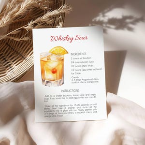 May include: A recipe card for a Whiskey Sour cocktail. The card features a watercolour illustration of the drink in a rocks glass with ice, a cherry, and an orange slice. The ingredients and instructions are listed.