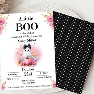 May include: A pink and white baby shower invitation with a ghost holding a pumpkin. The invitation says "A little BOO is almost due!" and includes the date, time, and location of the shower. It also includes the name of the person being celebrated, Stacy Minor, and the RSVP information.