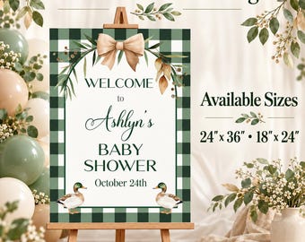 Könnte beinhalten: Ein rechteckiges Willkommensschild für eine Babyparty mit einem dunkelgrün-weißen Karomuster am Rand. In der Mitte steht der Text 'WELCOME to Ashlyn's BABY SHOWER October 24th' mit zwei Stockenten, einer beigen Schleife und Grünpflanzen. Verfügbare Größen sind 61 cm x 91 cm und 46 cm x 61 cm.