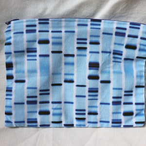 May include: A blue and white zippered pouch with a DNA pattern. The pouch is made of fabric and has a zipper closure.