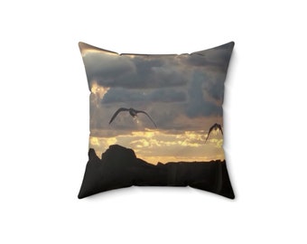 Puede incluir: Una almohada con un cielo de puesta de sol y pájaros en silueta volando sobre una cordillera.