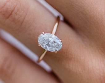 Könnte beinhalten: Nahaufnahme eines Verlobungsringes aus Roségold mit einem ovalen Diamanten.