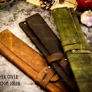 Pu&ograve; includere: Tre rotoli in pelle per coltelli in marrone, verde e marrone scuro. I rotoli hanno il testo "VIKINGS VALHALLA" stampato su di essi. Il testo "LEATHER COVER IN RANDOM COLOR" &egrave; stampato nella parte inferiore dell'immagine.