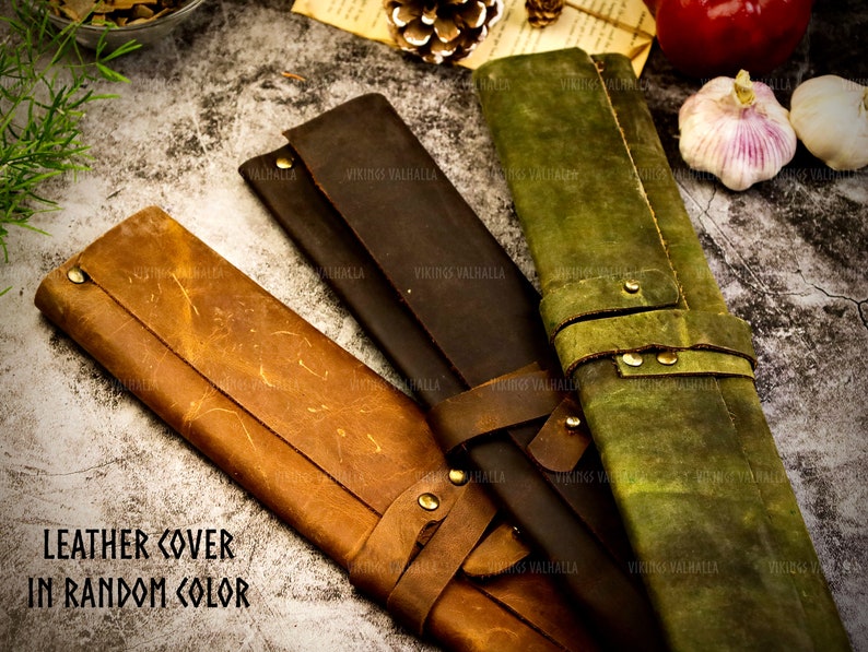 Pu&ograve; includere: Tre rotoli in pelle per coltelli in marrone, verde e marrone scuro. I rotoli hanno il testo "VIKINGS VALHALLA" stampato su di essi. Il testo "LEATHER COVER IN RANDOM COLOR" &egrave; stampato nella parte inferiore dell'immagine.