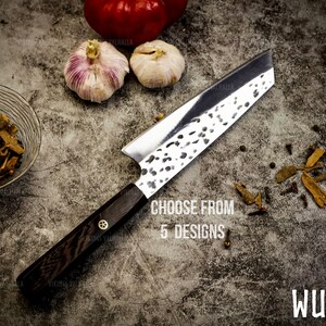 Pu&ograve; includere: Un coltello da cucina con manico nero e lama argentata con finitura martellata. Il coltello &egrave; appoggiato su una superficie grigia testurizzata con spezie sparse intorno. Il testo "Choose from 5 designs" &egrave; stampato sulla superficie. Il testo "WUNJO" &egrave; stampato nell'angolo in basso a destra dell'immagine.