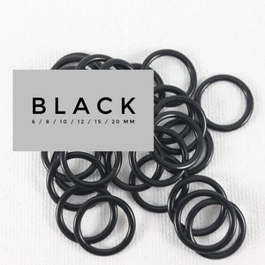 Könnte beinhalten: Ein Haufen schwarzer Metall-Sprünge in verschiedenen Größen von 6 mm bis 20 mm. Die Ringe sind zufällig auf einer weißen Oberfläche angeordnet. Der Text "BLACK 6 / 8 / 10 / 12 / 15 / 20 MM" ist im Bild sichtbar.