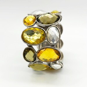 May include: A silver bracelet with a cluster of faceted yellow, clear, and green stones.